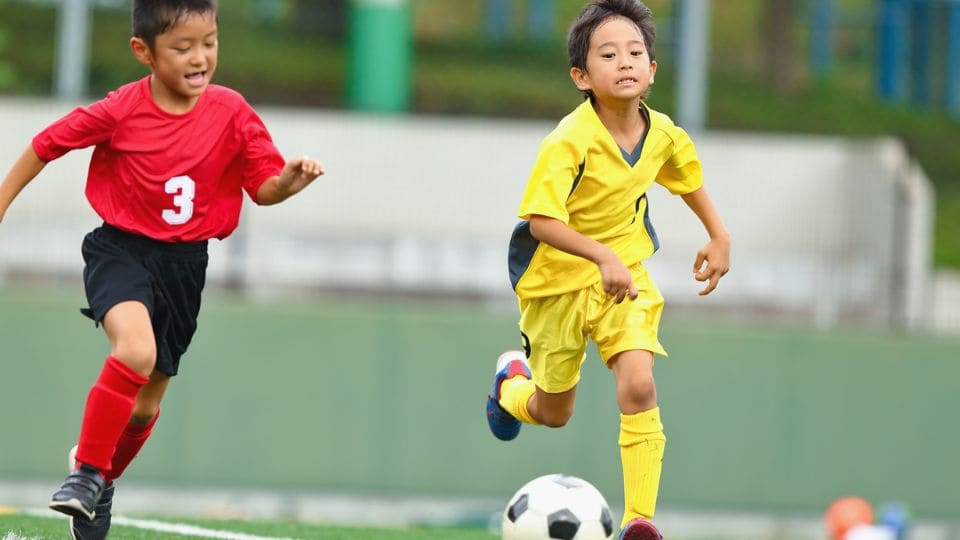 サッカーでドリブル突破する画像